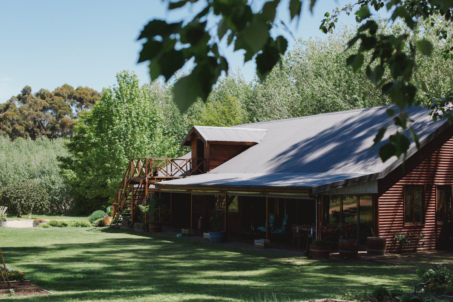 Melfort’s wooden exterior and shaded lawn, framed by trees
